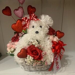 A silk flower pup in a basket.